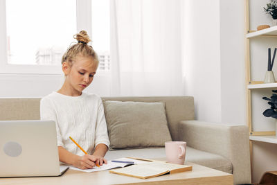 Young woman using laptop at home