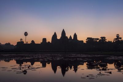 Silhouette of angkor wat against sky during sunset
