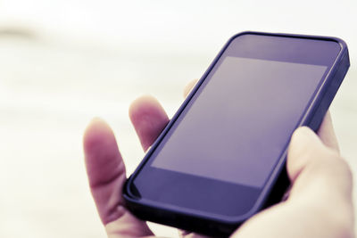 Close-up of human hand holding smart phone