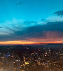 High angle view of illuminated city against sky at sunset