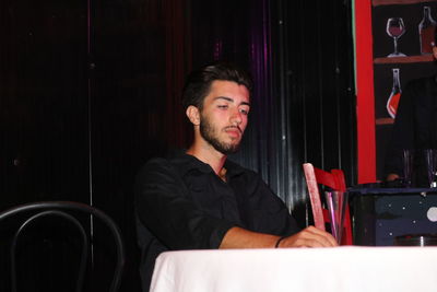 Young man sitting at table in restaurant