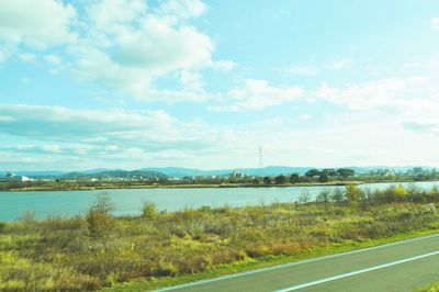 Scenic view of river by city against sky