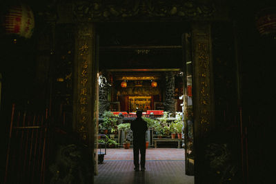 Rear view of man standing at entrance of building