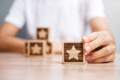 Midsection of man holding toy toys on table