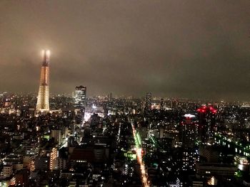 Illuminated cityscape against sky at night