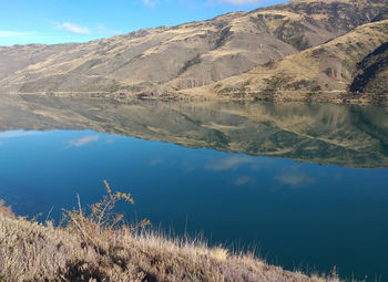 Scenic view of lake by mountains against sky