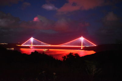 Illuminated suspension bridge at night