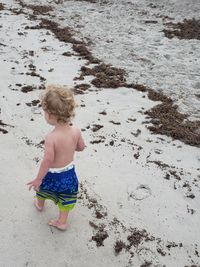 Shirtless boy walking at beach