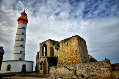 Low angle view of lighthouse against buildings