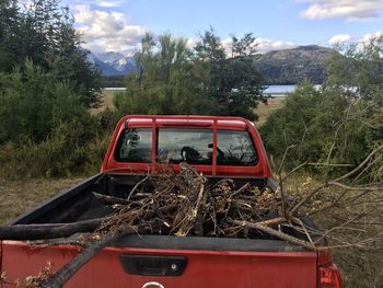 Abandoned car on land against sky