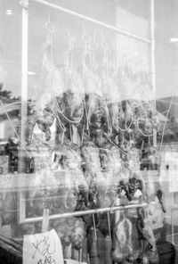 Digital composite image of people in store seen through glass window