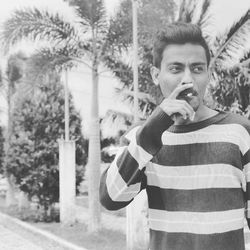 Man smoking cigarette while looking away outdoors