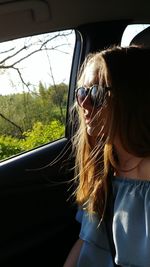 Woman wearing sunglasses while sitting in car