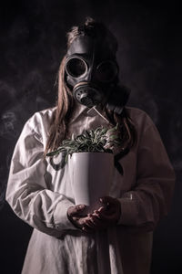 Portrait of mid adult man smoking against black background