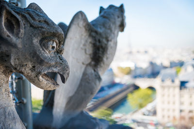 Close-up of statue against buildings