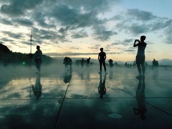 People on floor against sky during sunset