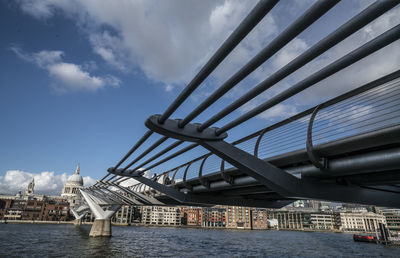 Bridge over river against sky in city