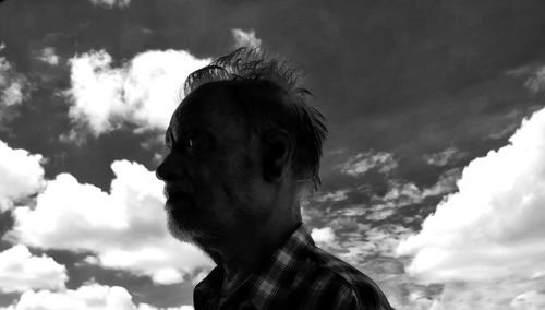 Portrait of dog looking away against sky