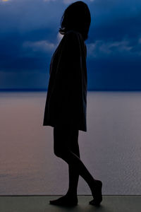 Rear view of woman standing at beach