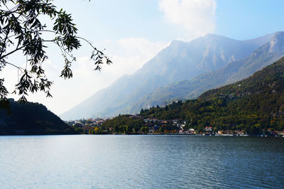 Scenic view of lake by mountains against sky