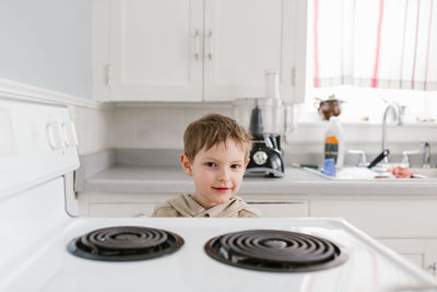 Portrait of boy standing in kitchen at home