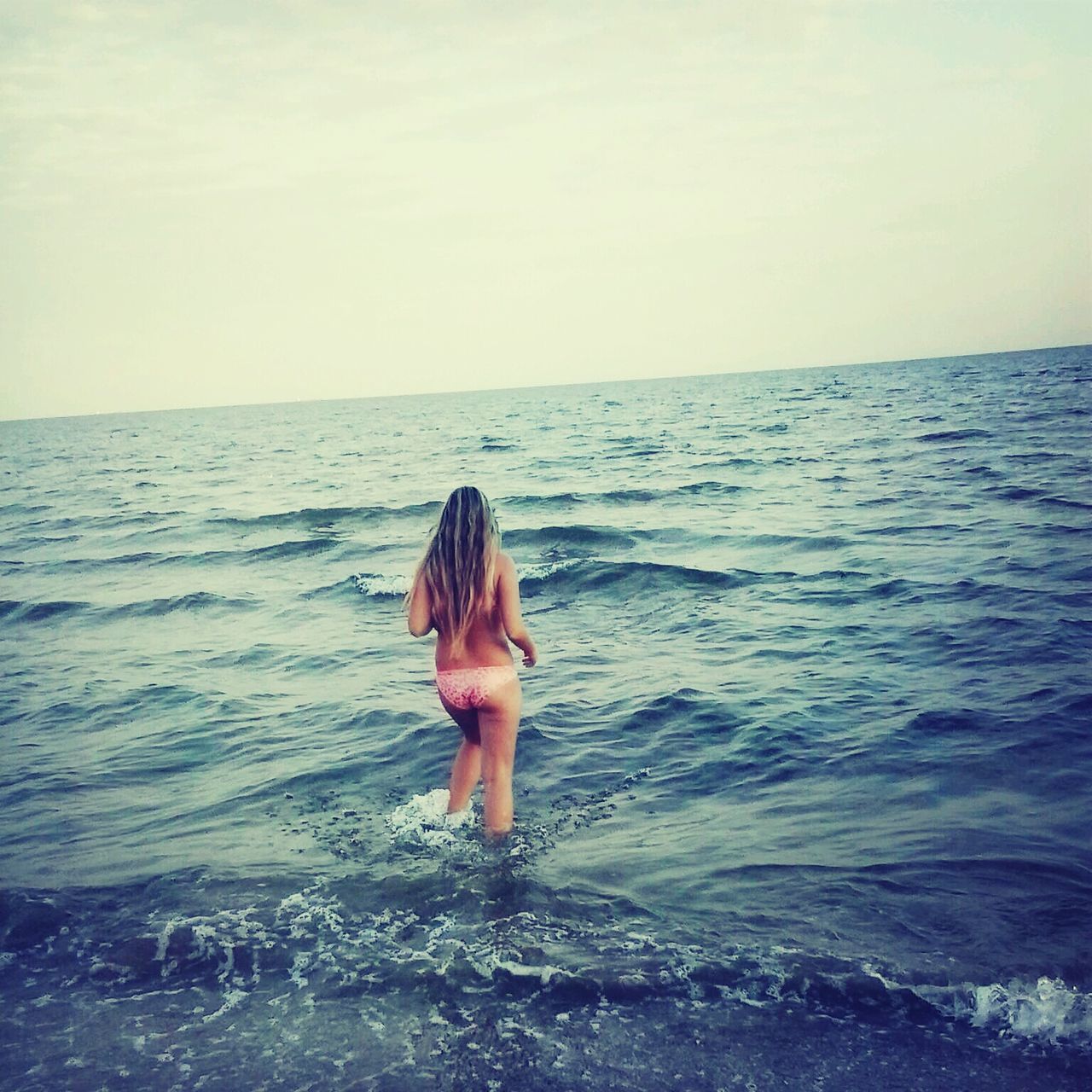 sea, water, horizon over water, lifestyles, leisure activity, person, standing, beach, rear view, vacations, scenics, beauty in nature, wave, tranquil scene, tranquility, nature, shore, young women