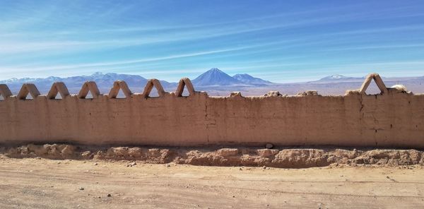 Panoramic view of arid landscape against blue sky