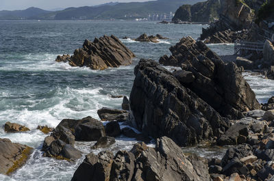 Rocks on sea shore against sky