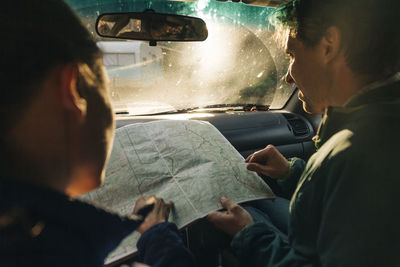 A young couple looks at the map on a road trip.