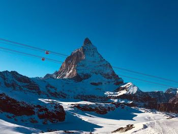 Scenic view of snowcapped mountains against clear blue sky