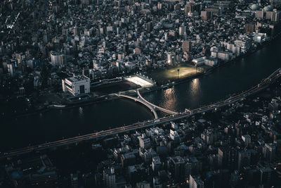 High angle view of river amidst buildings in city at night