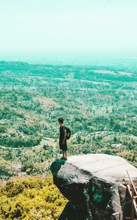 Full length of man standing on rock against sky