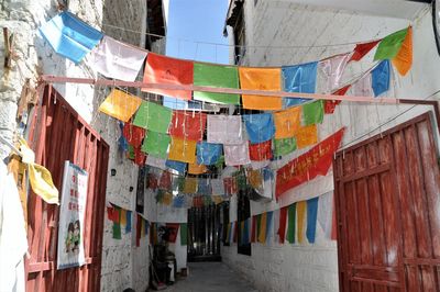 Low angle view of flags hanging on street amidst buildings