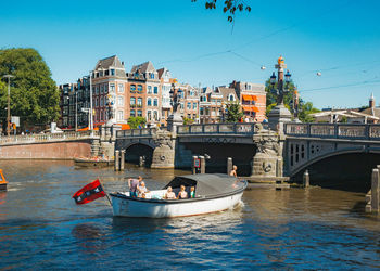 Bridge over river in city against clear sky