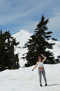 Full length of woman standing on snowcapped mountain against sky