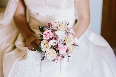 Midsection of bride holding bouquet