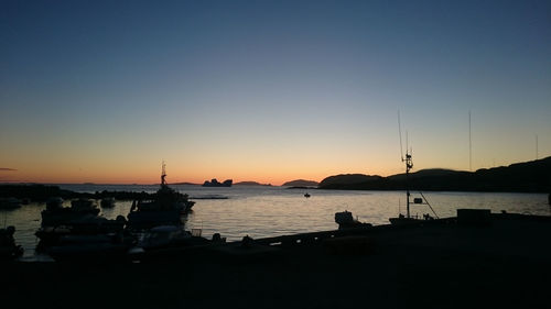 Boats in sea at sunset