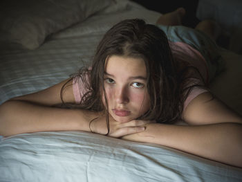 Portrait of girl lying on bed at home