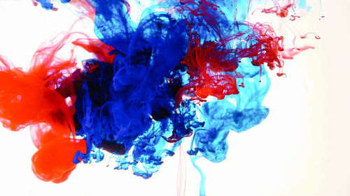 Close-up of colorful ink in water against white background