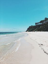 Scenic view of beach against clear blue sky