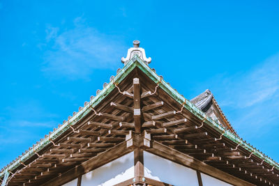 Low angle view of japanese traditional building against blue sky