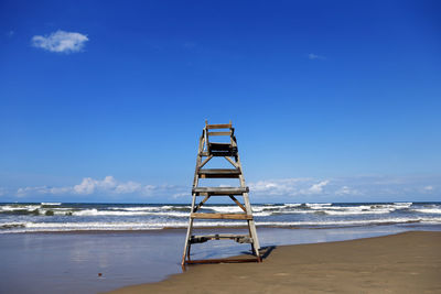 Lifeguard hut on beach against sky