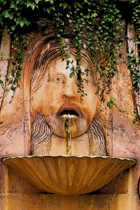 Statue of fountain against wall