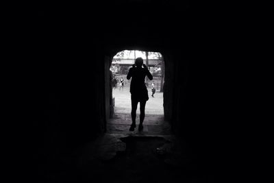 Silhouette person standing in tunnel