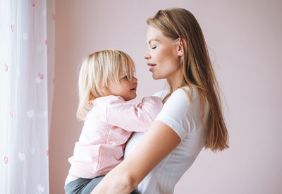 Side view of mother and daughter at home