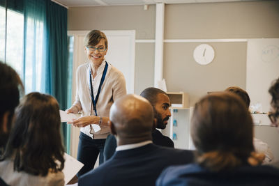 Smiling mature female entrepreneur with male and female colleagues in office seminar