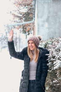 Portrait of smiling woman standing in snow