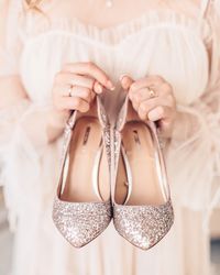 Midsection of woman holding glittering footwear