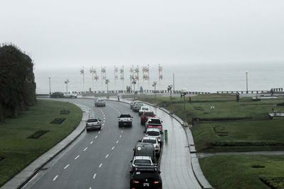High angle view of cars on road by sea against sky