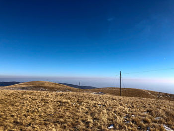 Scenic view of field against clear blue sky
